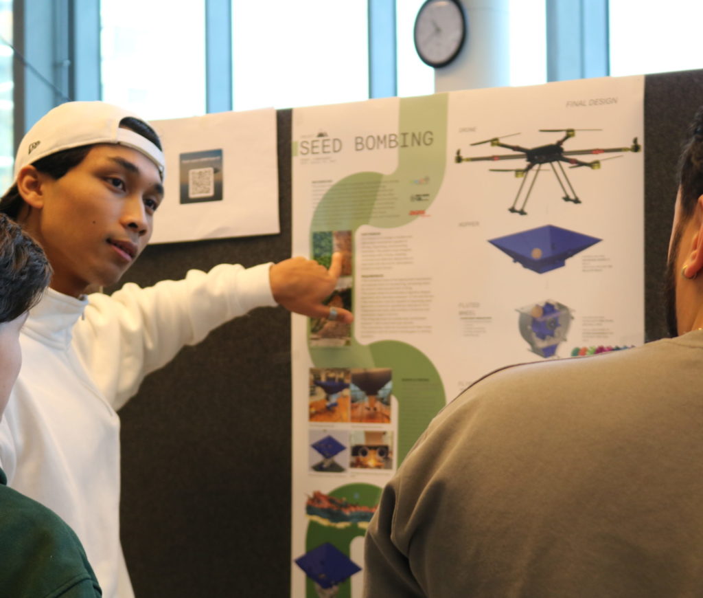 Student explaining seed bombing drone poster